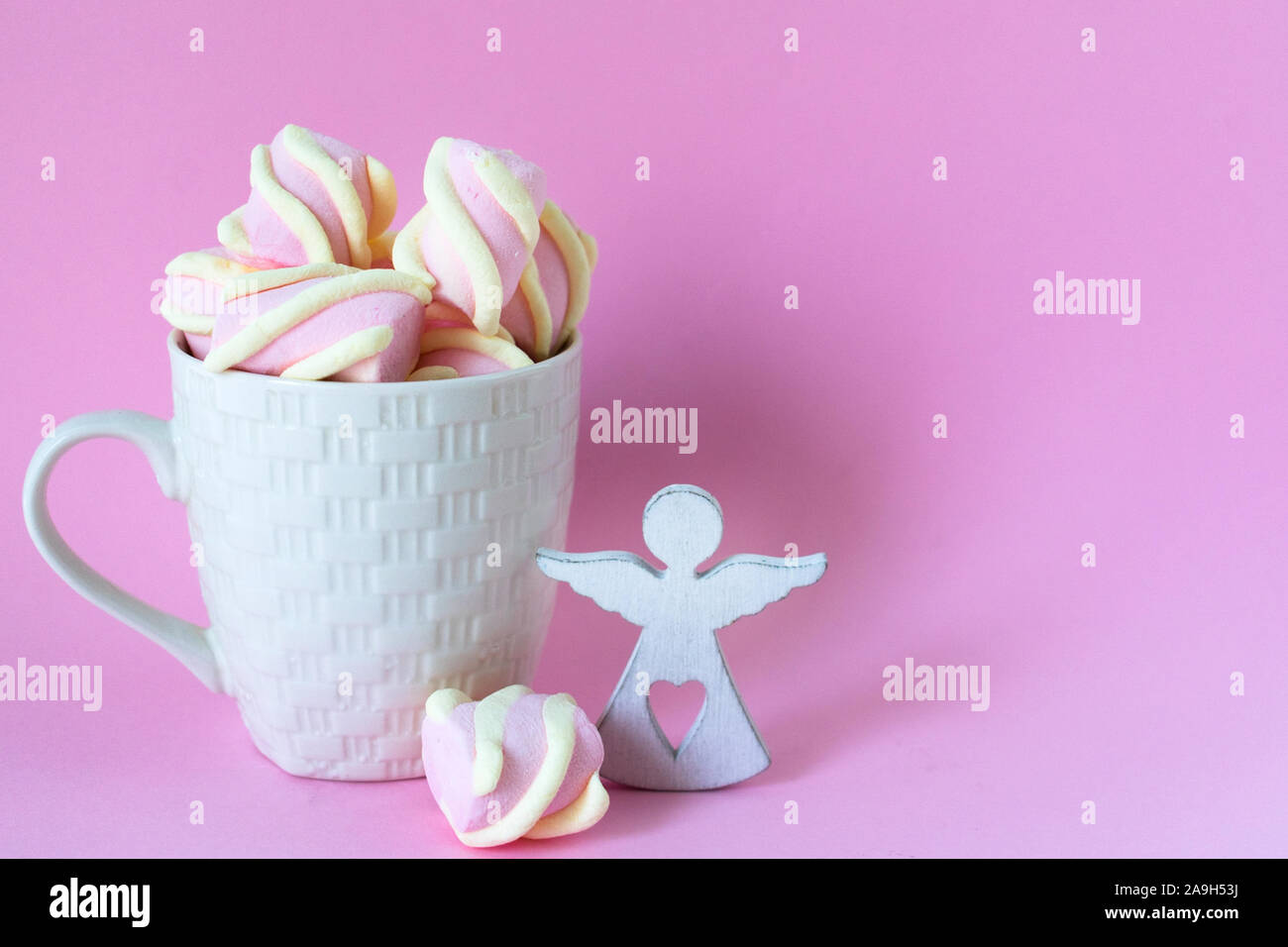 Weiße Tasse Schokolade mit rosa Marshmallows auf einem rosa Hintergrund. Kopieren Sie Platz. Stockfoto