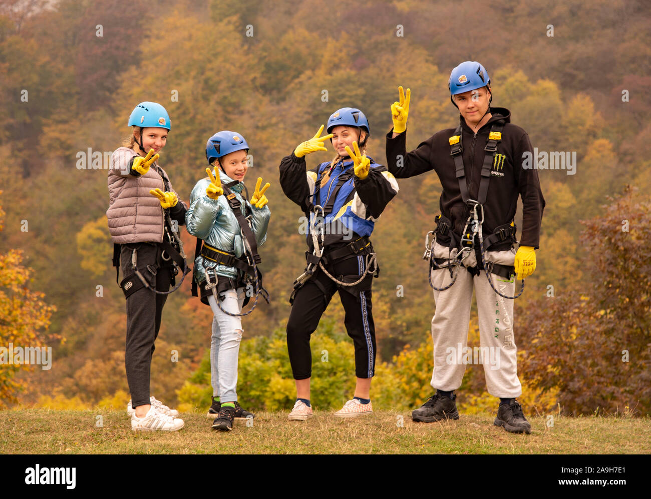 Armenien, enokavan, Oktober 2019. Vier Teenager in die zipline Ausrüstung stellen vor dem Hintergrund der Herbst Wald. Stockfoto