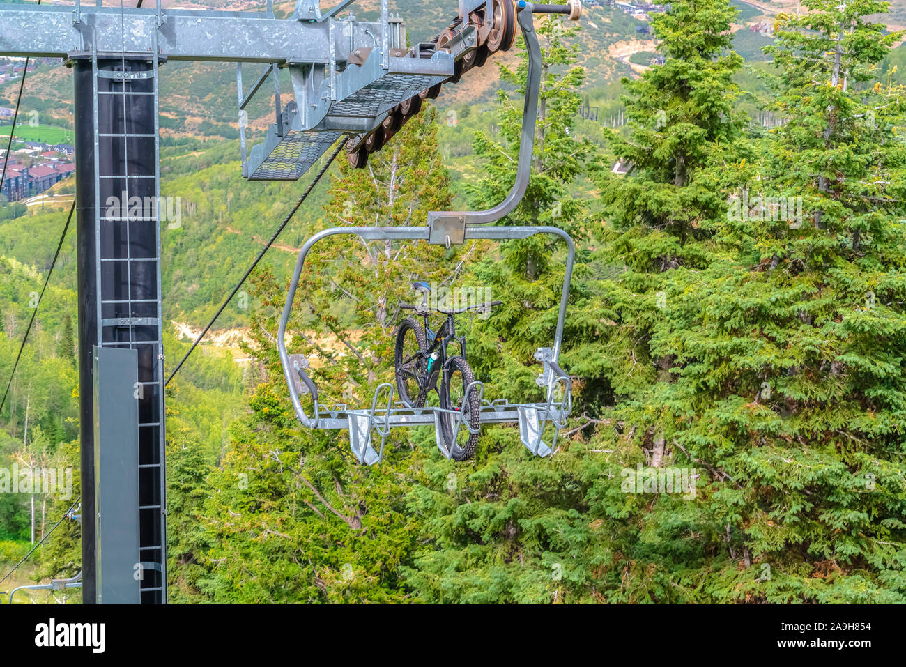 Mountainbike auf eine Hebebühne gegen Bäume im Park City Ski Resort in der Nebensaison Stockfoto