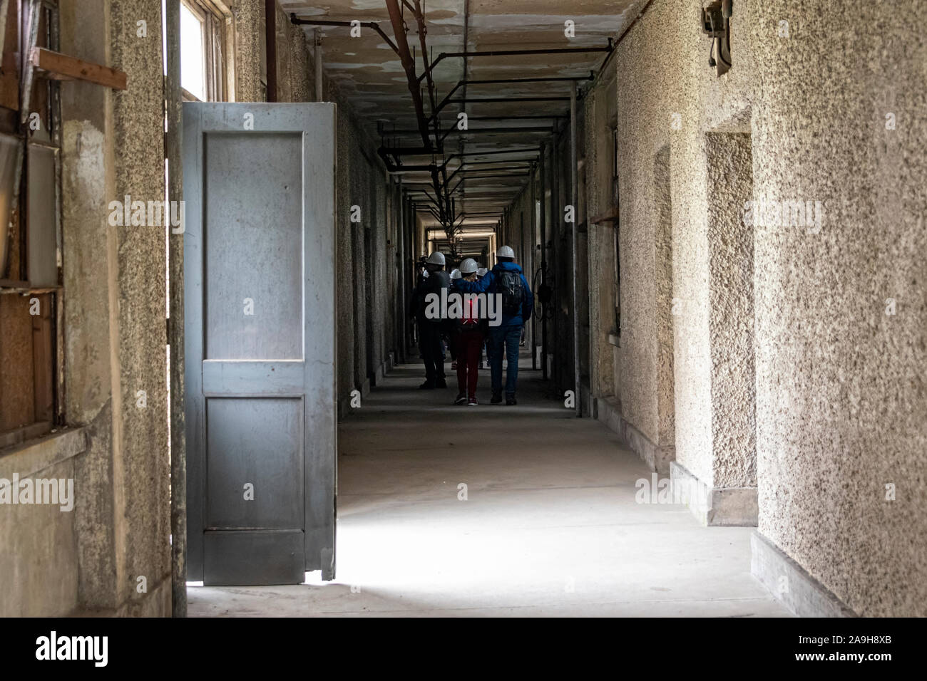 USA, New York, Ellis Island - Mai 2019: Tour Gruppe, das Tragen von Schutzhelmen, die durch das Krankenhaus, auf Ellis Island Stockfoto