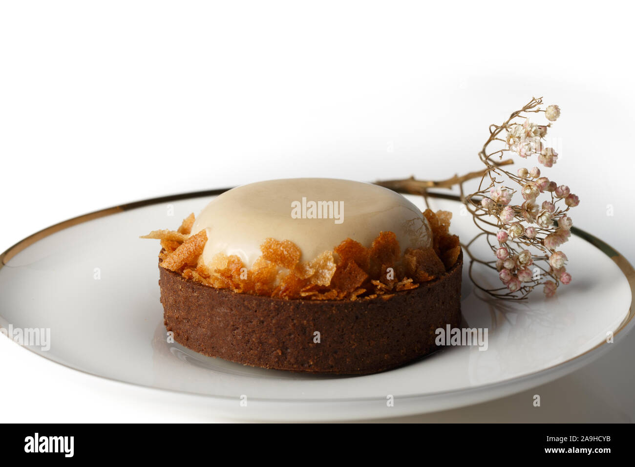 Nahaufnahme von rund weiß glasierten Kuchen mit Keks Krümel auf weiße Platte. Stockfoto