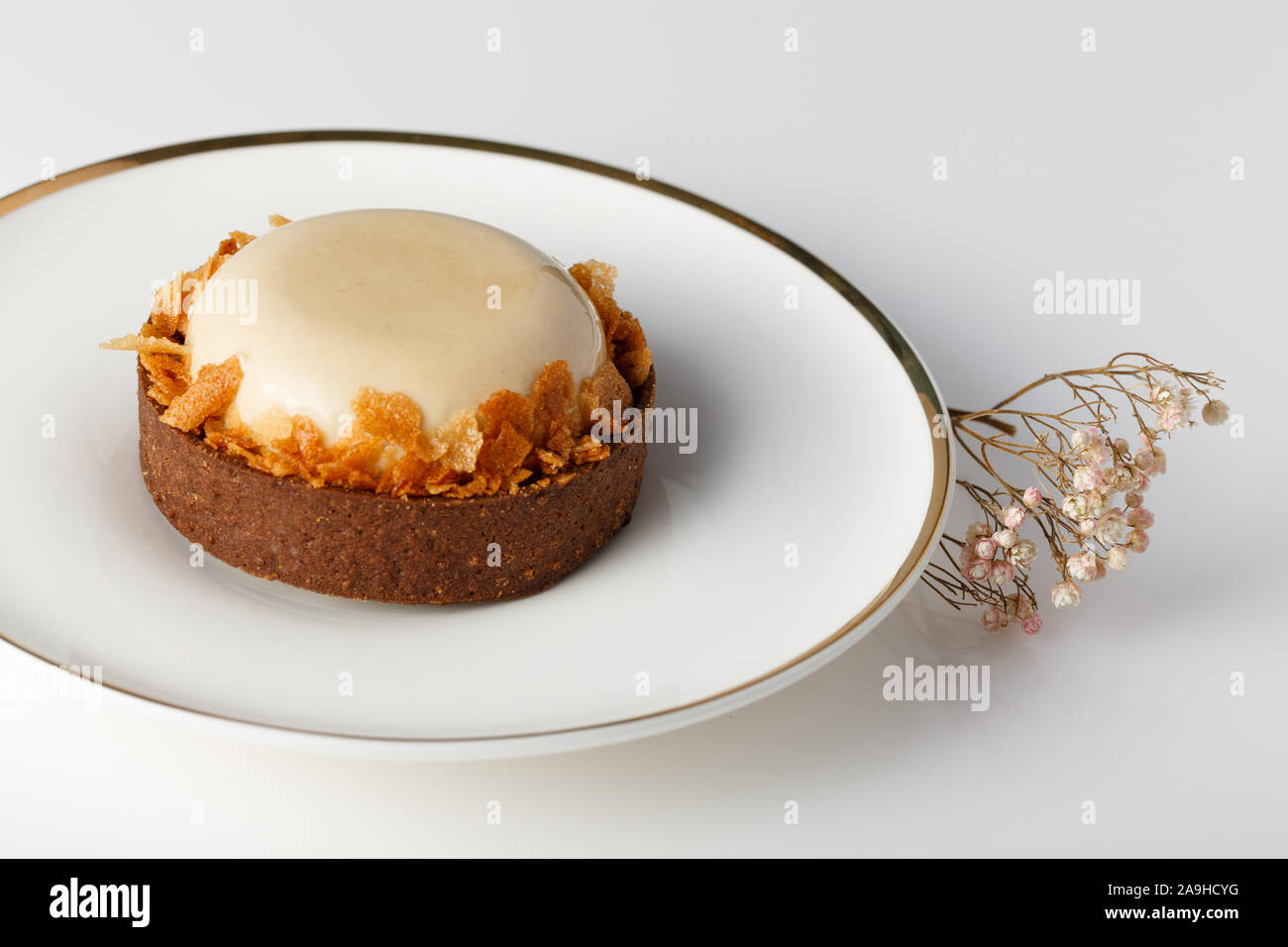 Nahaufnahme von rund weiß glasierten Kuchen mit Keks Krümel auf weiße Platte. Stockfoto