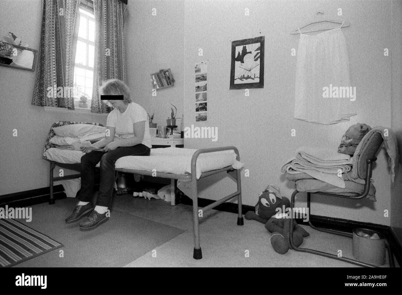 Frau in Gefängniszelle UK 1980 Weibliche Häftlinge, die Briefe im eigenen Zimmer liest und auf dem Bett sitzt. HM Gefängnis Styal Wilmslow Cheshire England 1986 HOMER SYKES Stockfoto