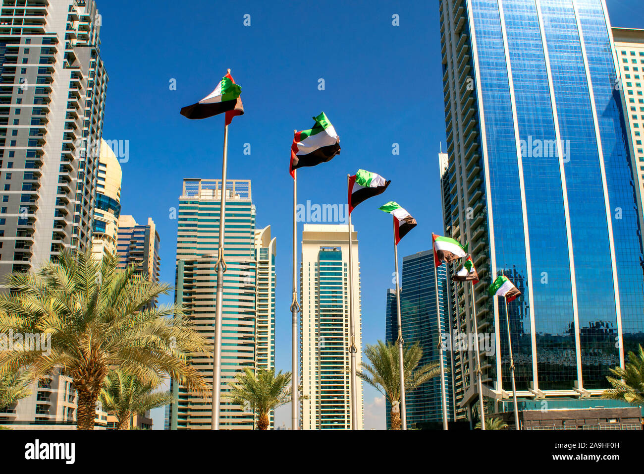 Gebäude mit Blick über Dubai Vae Fahnen. Vereinigte Arabische Emirate Fahnen schwenkten auf blauen Himmel Hintergrund. Tag der Unabhängigkeit. Vae Fahnen auf der Straße. Flag Tag Stockfoto