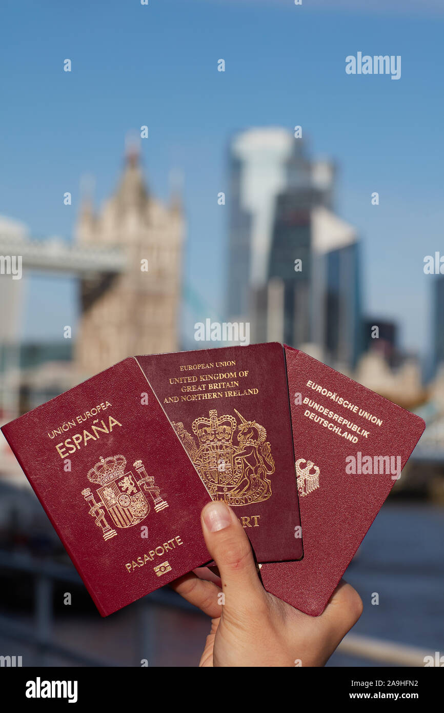 Hand mit einem britischen Paß zusammen mit anderen EU-Pass gegen London Landmark. Reisen nach Brexit. Stockfoto