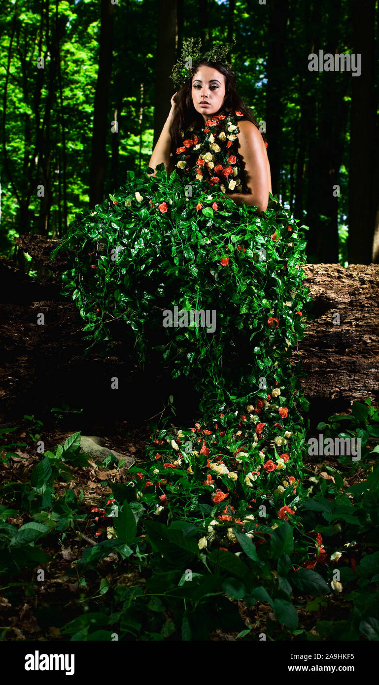 Outdoor High Fashion der Frau in Kleid aus Blättern und Rosen Stockfoto