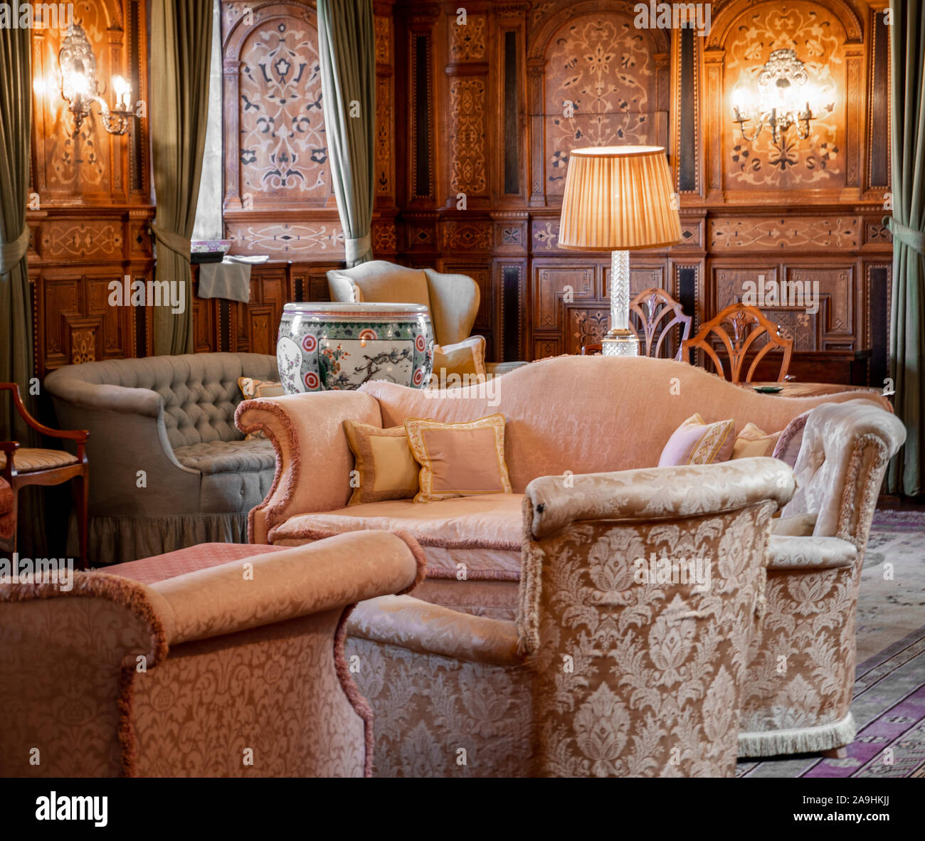 Gemütliches Wohnzimmer mit rosa Sofa und hölzerne Wände Stockfoto