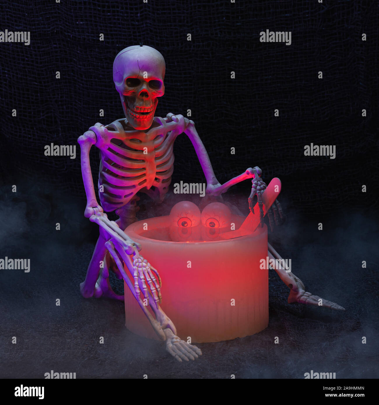 Halloween Urlaub noch Leben eines roten elektrischen Wachs Kerze und ein Skelett mit künstliche Augäpfel floating im Innern Kerze Stockfoto
