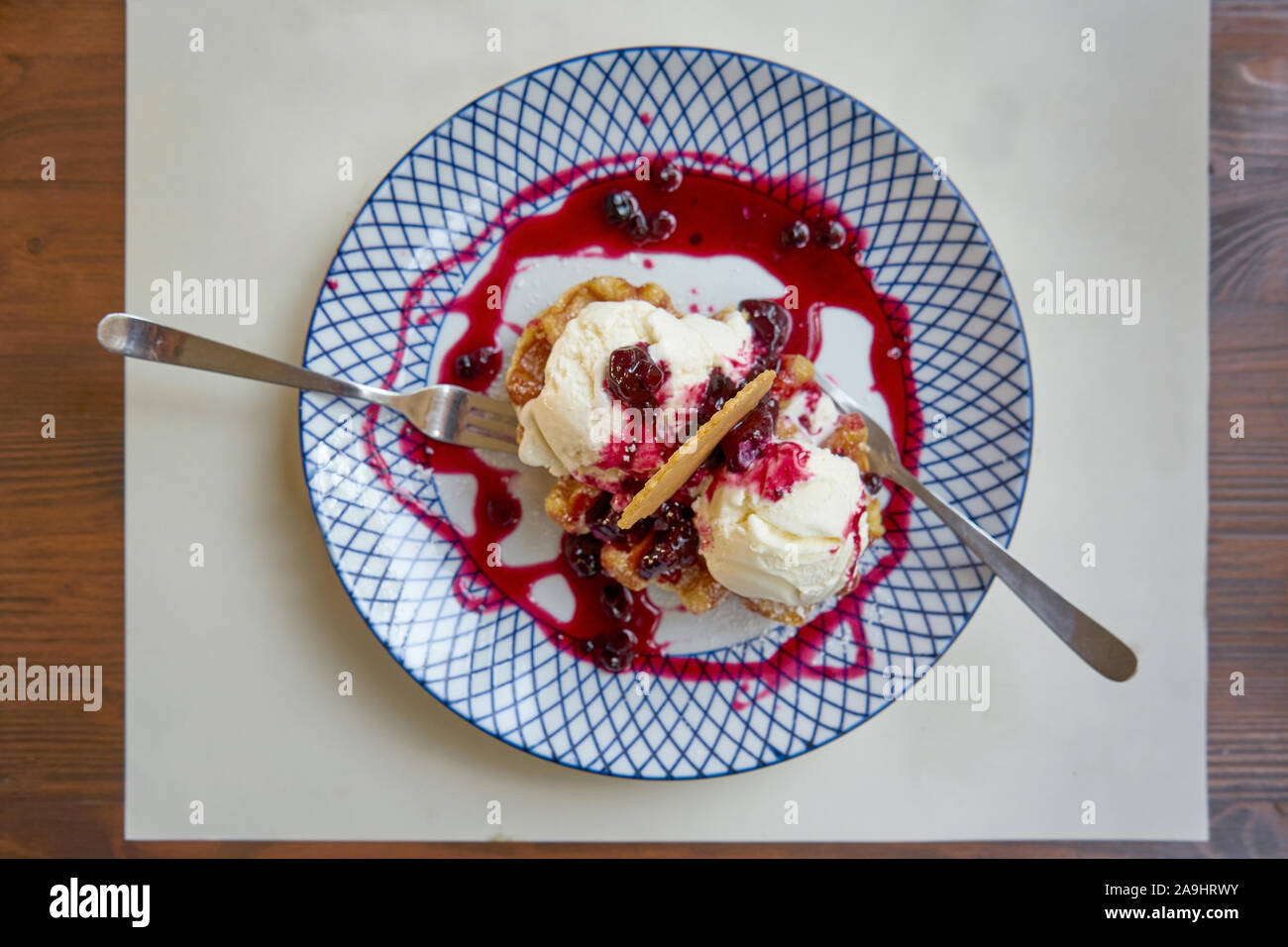 Vanilleeis serviert auf einem Teller mit Waldbeeren Dressing und Wafer Stockfoto