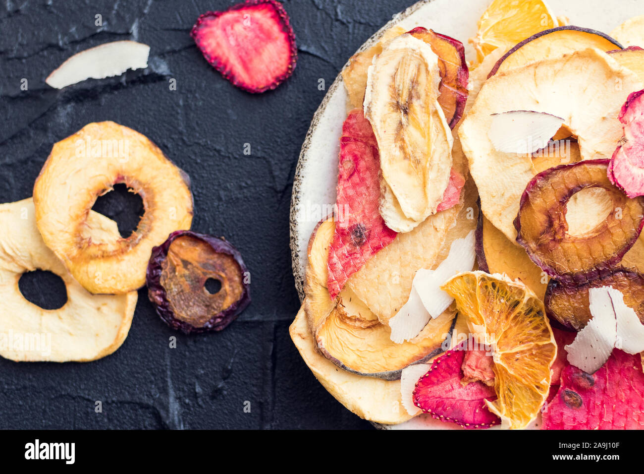 Gesunde hausgemachte Frucht Chips von Apple, Orange, Banane, Erdbeere auf grauem Hintergrund. Bio Diät essen. Die vegane Ernährung. Getrocknete Früchte. Vegetarische pl Stockfoto