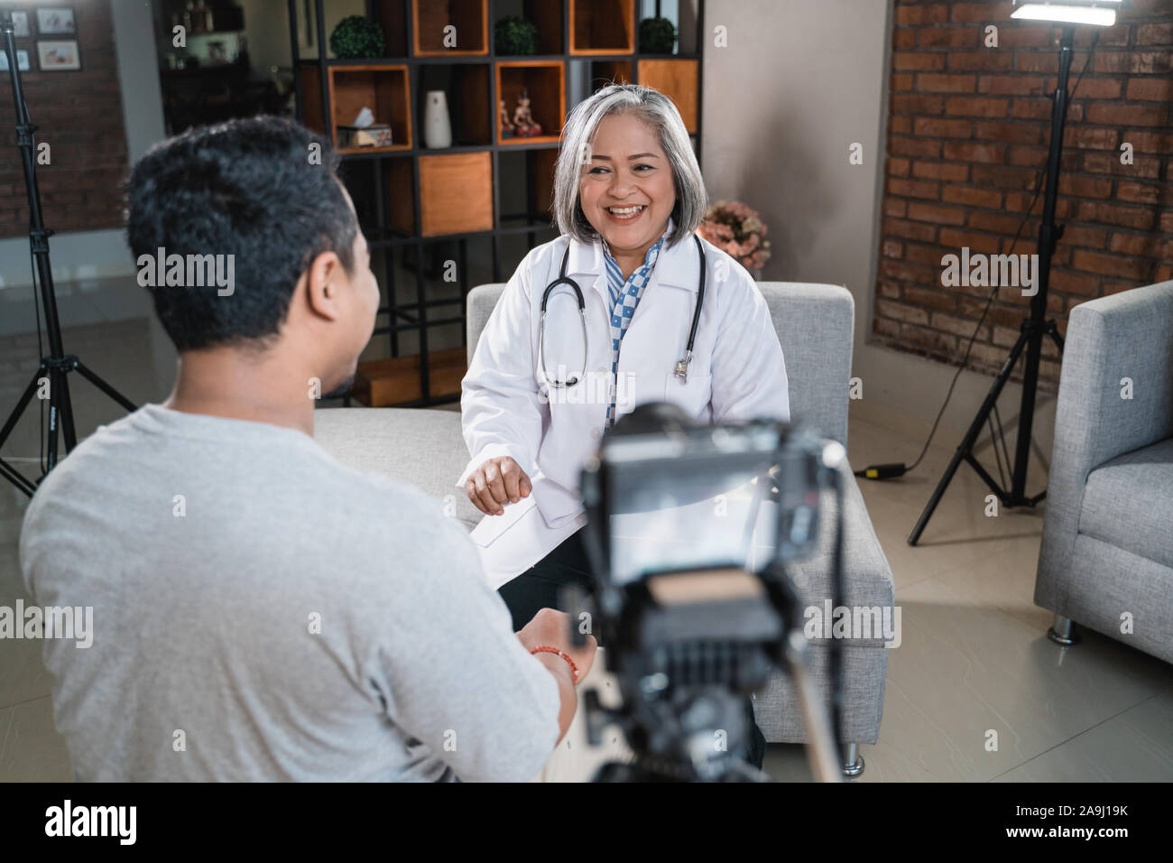Arzt im Gespräch mit dem Patienten und die Aufnahme mit Kamera Stockfoto