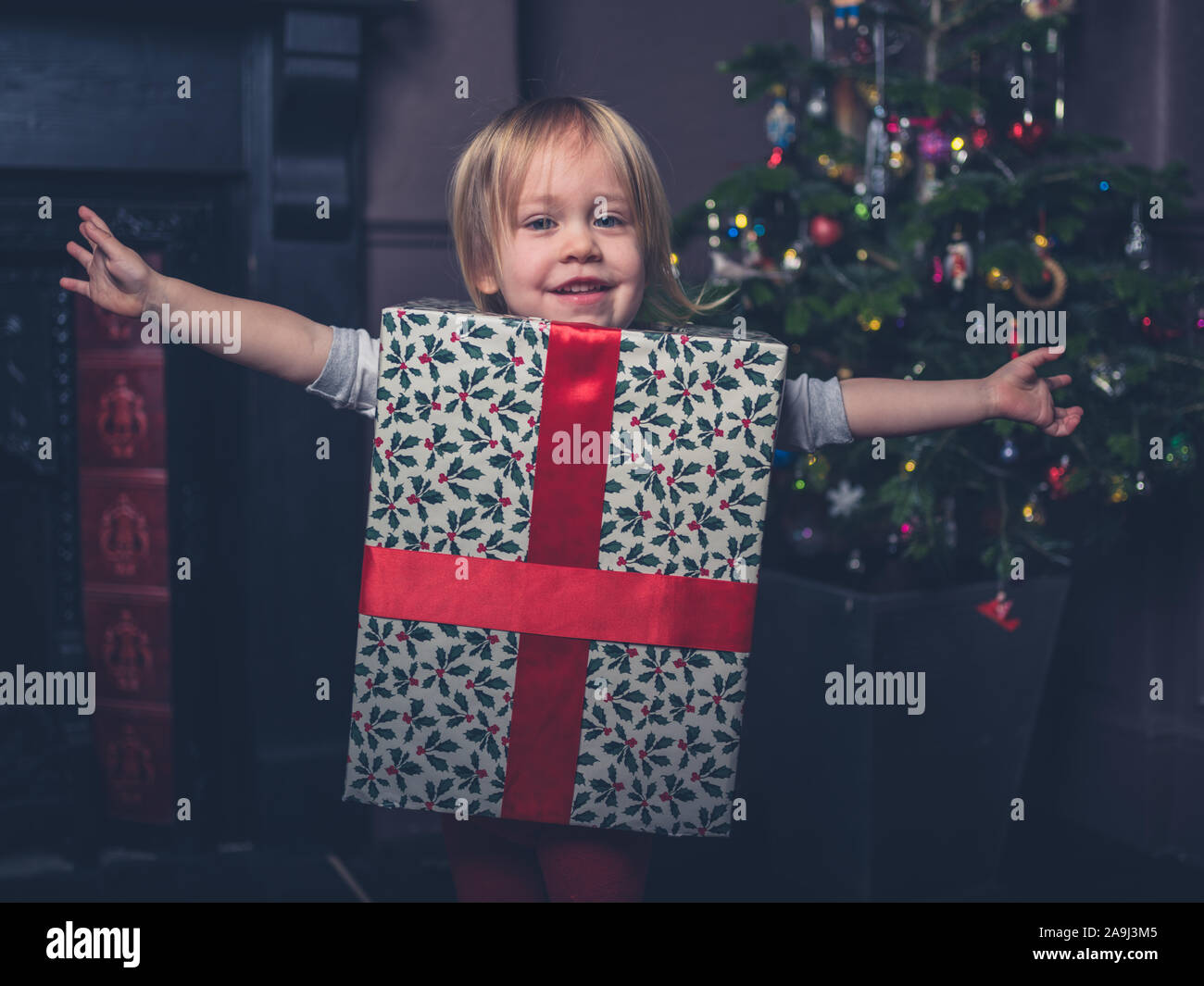 Ein glückliches Kind ist wie ein Weihnachtsgeschenk von der Baum angezogen Stockfoto