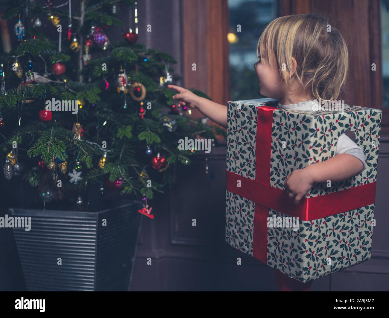 Ein glückliches Kind ist wie ein Weihnachtsgeschenk von der Baum angezogen Stockfoto