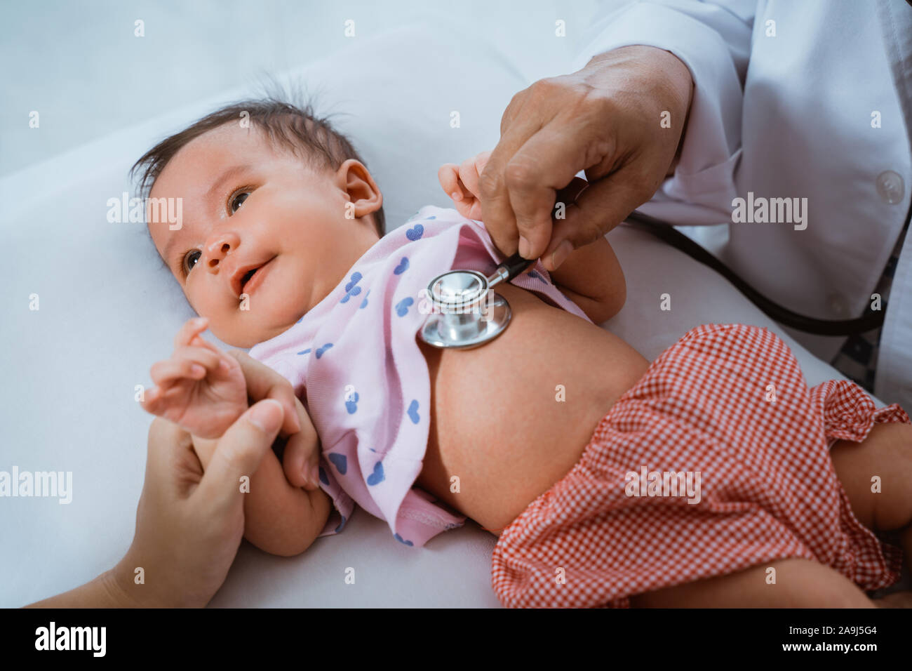 Kleines Baby, während sie von Arzt untersucht Stockfoto