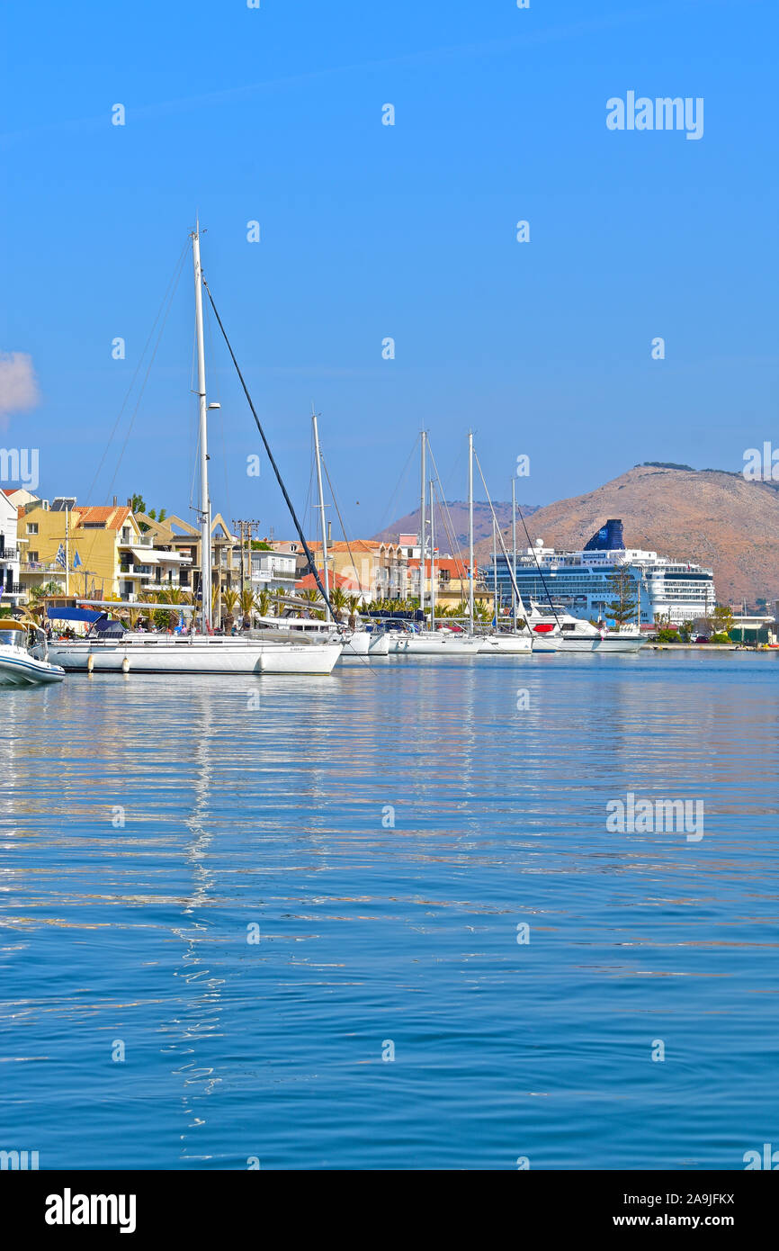 Einen malerischen Blick über den Hafen von Argostoli, mit Yachten festgemacht am Kai Seite und ein Kreuzfahrtschiff am Terminal geboren. Berge im Hintergrund. Stockfoto