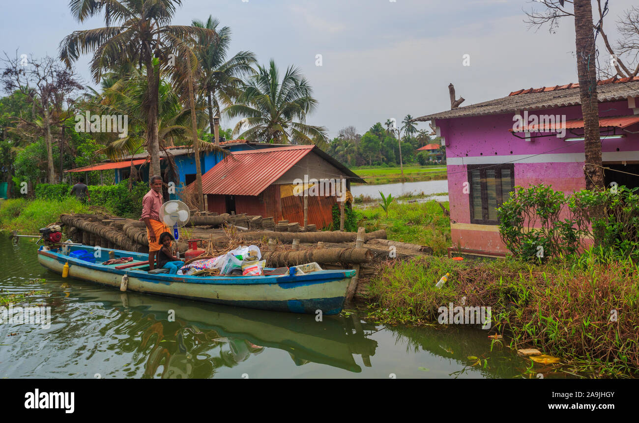 Ein Dorfbewohner den Transport von Futtermitteln in einem Holzboot in Alleppey (Kerala, Indien) Stockfoto