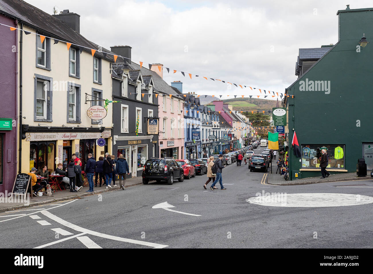 Pubs, Geschäfte, Hotels und Restaurants auf einer Straße in Kenmare, dekoriert mit Halloween falgs, County Kerry, Republik von Irland Stockfoto