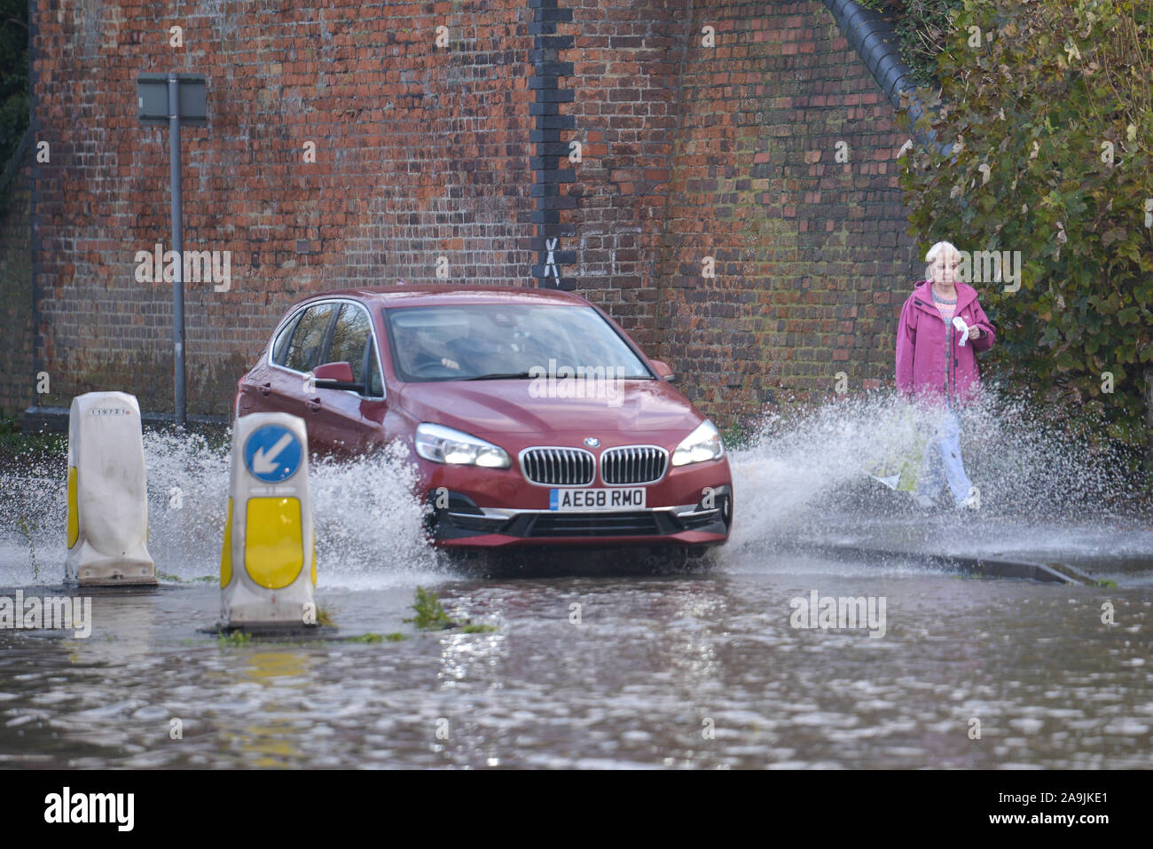 Tewkesbury, Gloucestershire, Vereinigtes Königreich. November 2019. Ein Auto plätschert einen Fußgänger, während er durch Überschwemmungen im Stadtzentrum von Tewkesbury fährt, das von schweren Überschwemmungen heimgesucht wurde, als der Fluss Avon seine Ufer geplatzt hat. Der Flussspiegel steigt weiter an und wird voraussichtlich am späten Samstagnachmittag über 12 Meter über dem normalen Flussniveau steigen. Bild aufgenommen am 16.11.2019. Quelle: Stop Press Media/Alamy Live News Stockfoto