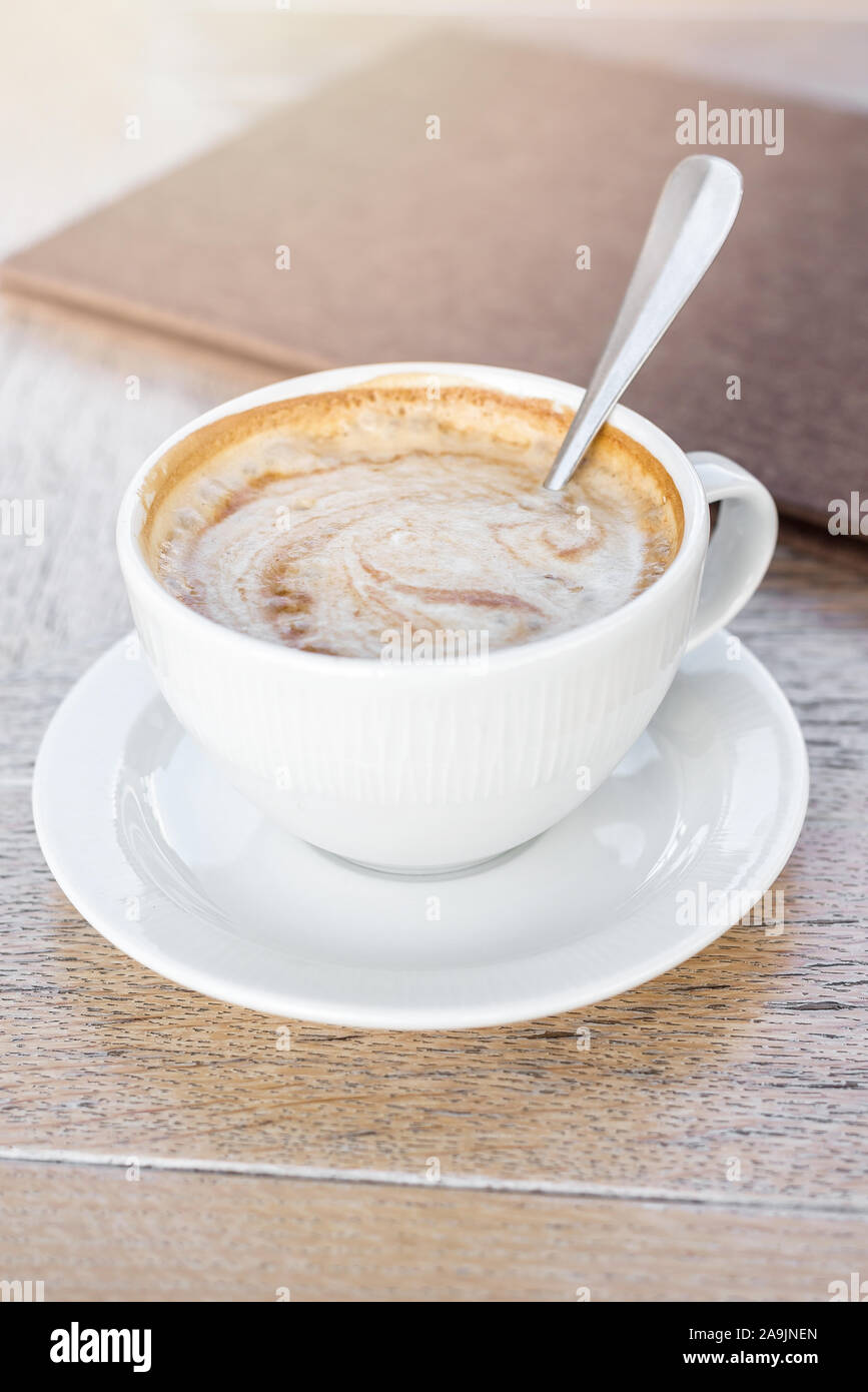 Weiße große Tasse köstlichen Kaffee auf Holztisch im Sonnenlicht. Stockfoto