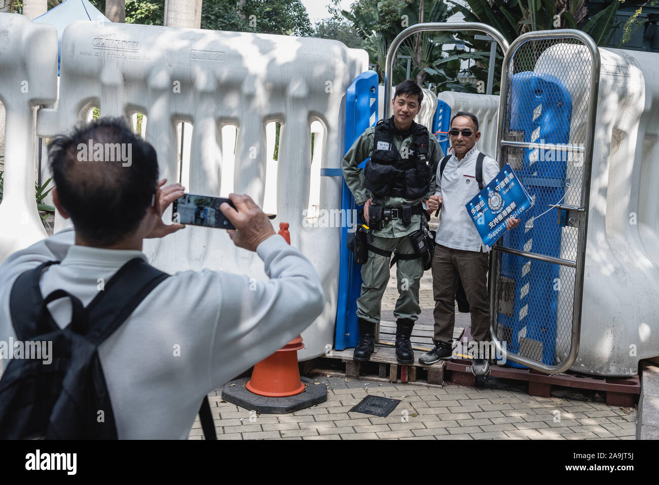 Hongkong, China. 16. Nov 2019. ein Pro - Polizei Unterstützer und ein Polizist posiert für ein Foto vor einer Polizeistation während des Protestes. Über hundert pro-Polizei Demonstranten versammelten außerhalb der Regierung Büros zur Unterstützung der Hongkonger Polizei. Unterstützer wellen Fahnen und Plakaten während verschiedene Slogans riefen zur Unterstützung der Polizei, die unter intensiver Kontrolle und Kritik über ihre Handhabung der laufenden Protesten gekommen. Credit: SOPA Images Limited/Alamy leben Nachrichten Stockfoto