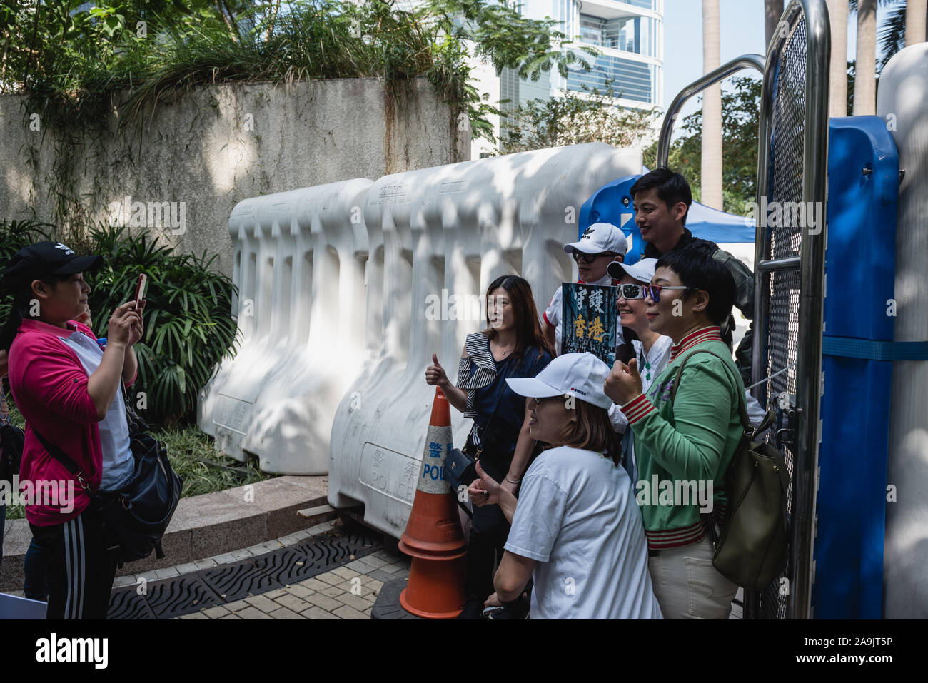 Hongkong, China. 16. Nov 2019. Pro-Polizei Unterstützer und ein Polizist für ein Foto vor einer Polizeistation während des Protestes darstellen. Über hundert pro-Polizei Demonstranten versammelten außerhalb der Regierung Büros zur Unterstützung der Hongkonger Polizei. Unterstützer wellen Fahnen und Plakaten während verschiedene Slogans riefen zur Unterstützung der Polizei, die unter intensiver Kontrolle und Kritik über ihre Handhabung der laufenden Protesten gekommen. Während die Polizei von Fehlverhalten in den letzten Monaten mehrfach beschuldigt worden sind, bleibt immer noch ein starkes Kontingent der Polizei - Anhänger innerhalb der Stadt. Stockfoto