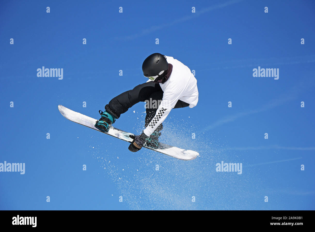 Snowboarder durch Luft mit blauen Himmel im Hintergrund springen Stockfoto