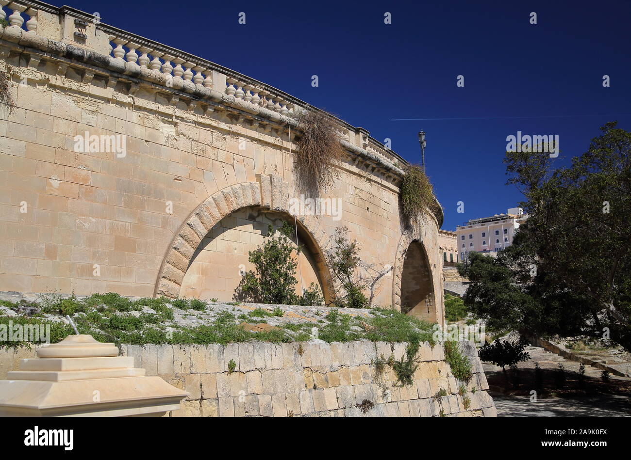 Historische Mauer befestigte Zentrum von Valett, Hauptstadt von Malta, gegen den blauen Himmel, direkt neben dem Park, Garten mit grünen Bäumen, ohne dass die Leute Stockfoto