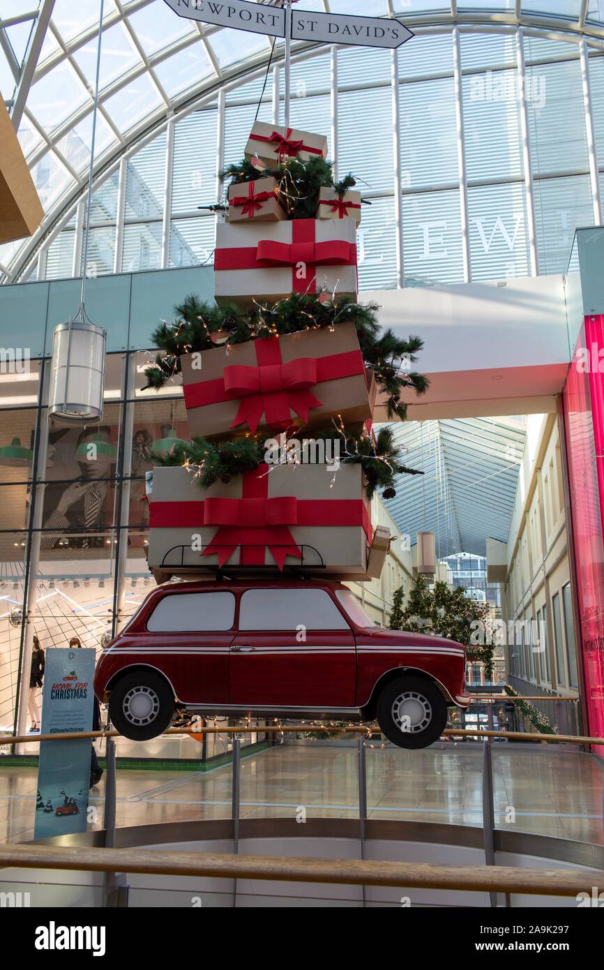 Cardiff, Glamorgan, Wales, Großbritannien, 16. November 2019 Weihnachtsdekorationen themed um nach Hause fahren zu Weihnachten in St David's Shopping Centre in Cardiff gesehen, mit einem ikonischen Modell eines Mini hoch mit präsentiert von der Decke abgehängt. Credit: Ian Jones/Alamy leben Nachrichten Stockfoto