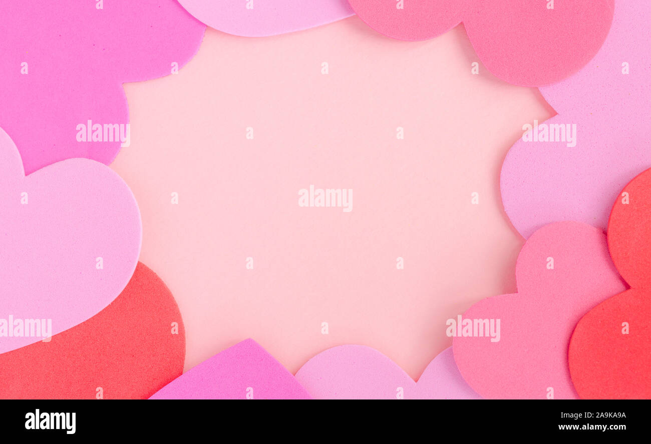 Von oben nach unten Blick auf rosa und rote Liebe Herzen arrangiert in einem Rahmen und auf einem rosa Hintergrund mit Kopie der Platz in einem Valentine feier Bild Stockfoto