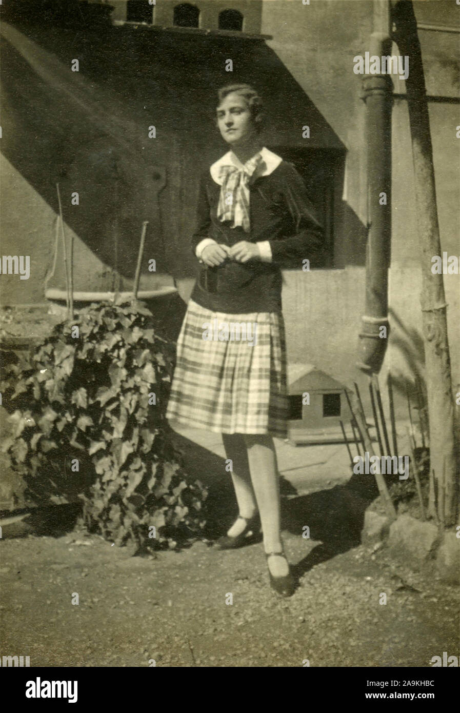 Ein Mädchen mit kurzen Haaren trägt einen karierten rock und einen Bogen, Italien Stockfoto
