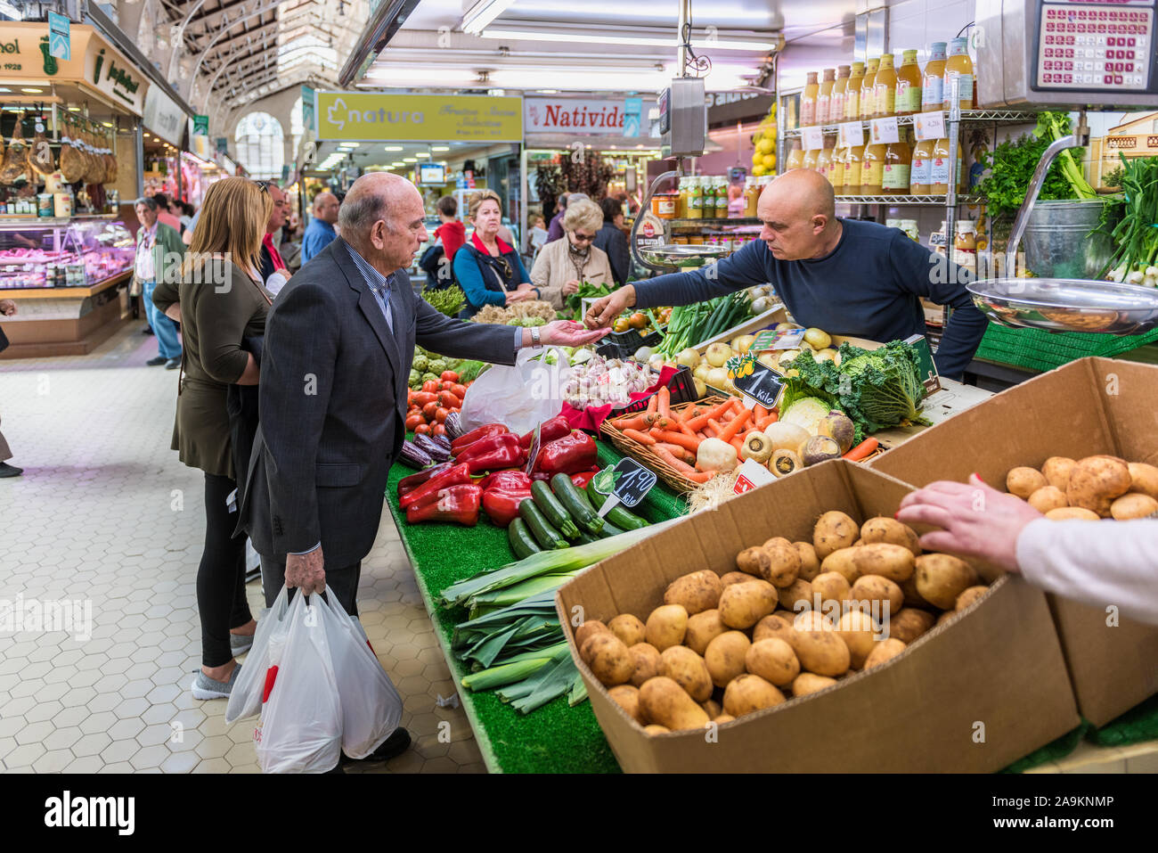 Man erhält nach dem Kauf von Lebensmitteln aus einem Händler Platz in der Mercado Central (Zentrale Markt) in Valencia Spanien ändern Stockfoto