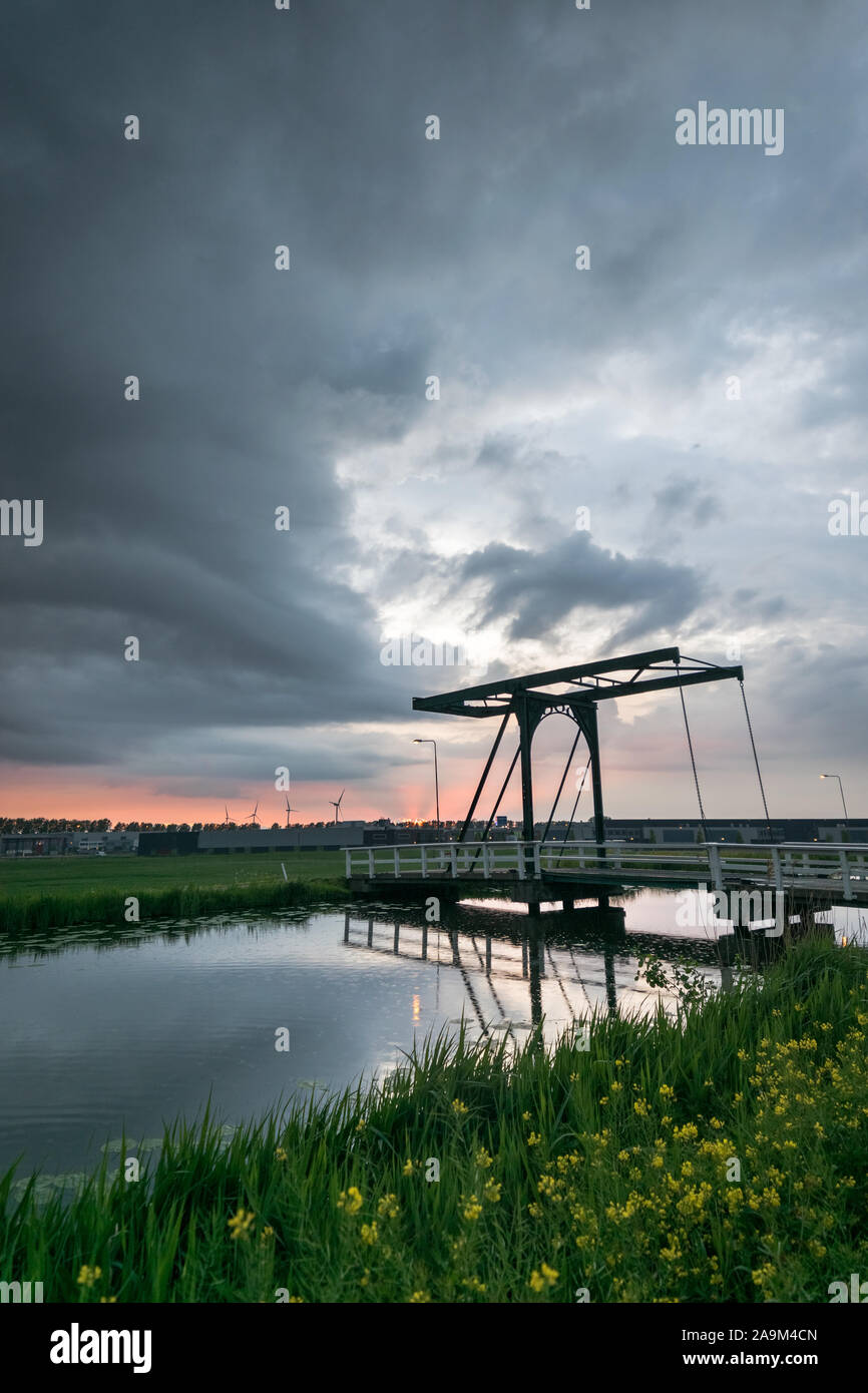 Draw Bridge in der Nähe von einem niederländischen Canal in der Nähe der Stadt Gouda, Niederlande mit einem Ominösen storm Cloud im Hintergrund Stockfoto
