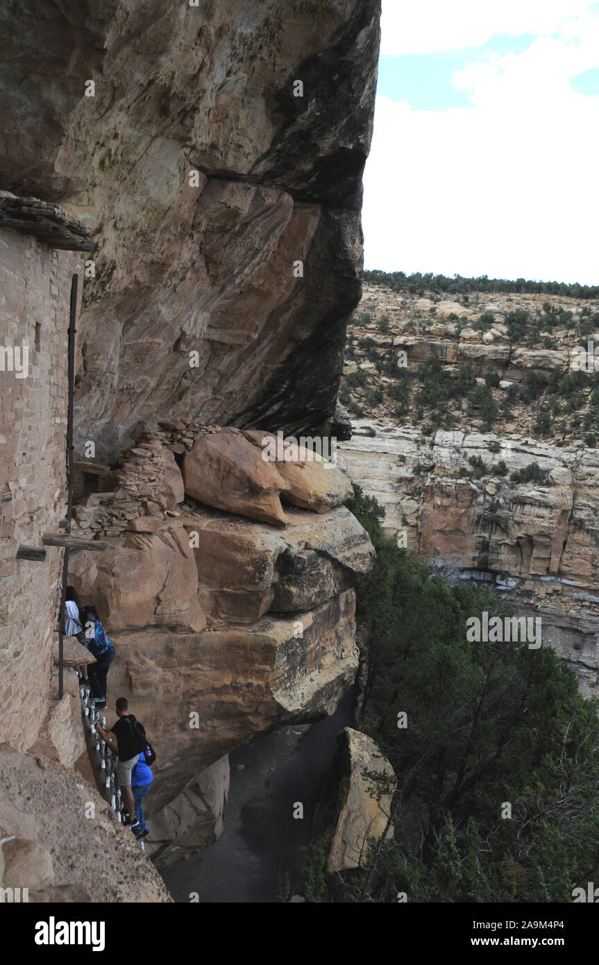 Balkon Haus in Mesa Verde National Park, Colorado sind uralten Pueblo Ruinen. Ein Ranger Leitung Gruppe klettert eine der Seiten lange Leitern. Stockfoto