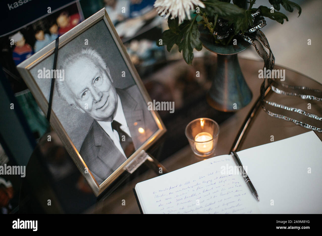 16 November 2019, Sachsen, Morgenröthe-Rautenkranz: ein Kondolenzbuch, eine Kerze, Blumen und ein Portrait stand während einer Trauerfeier der DDR space traveller Sigmund Jähn an der Deutschen Space Center. Foto: Oliver Killig/dpa-Zentralbild/dpa Stockfoto