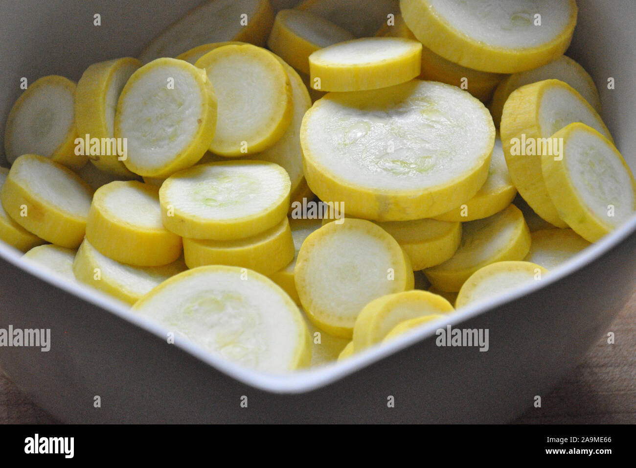 Gelb Sommer Kürbis in Scheiben geschnitten in einer weißen Schüssel Stockfoto