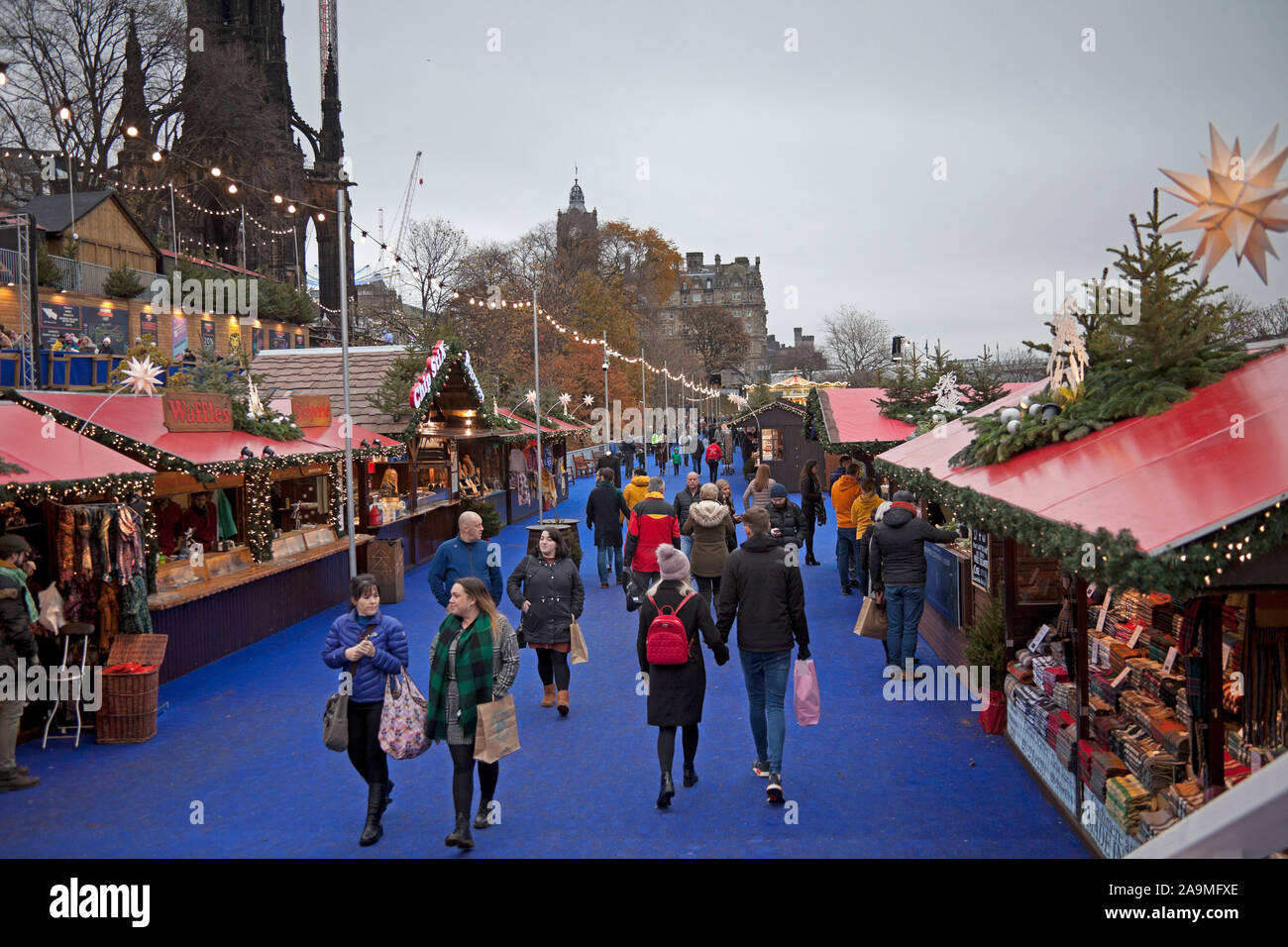 Die Princes Street Gardens, Edinburgh, Schottland, Vereinigtes Königreich. 16. November 2019. Weihnachtsmarkt und Kirmes öffnet zu spät. Menschen Mühle rund um die Stände auf der Suche nach Geschenke und Geschenke. Stockfoto