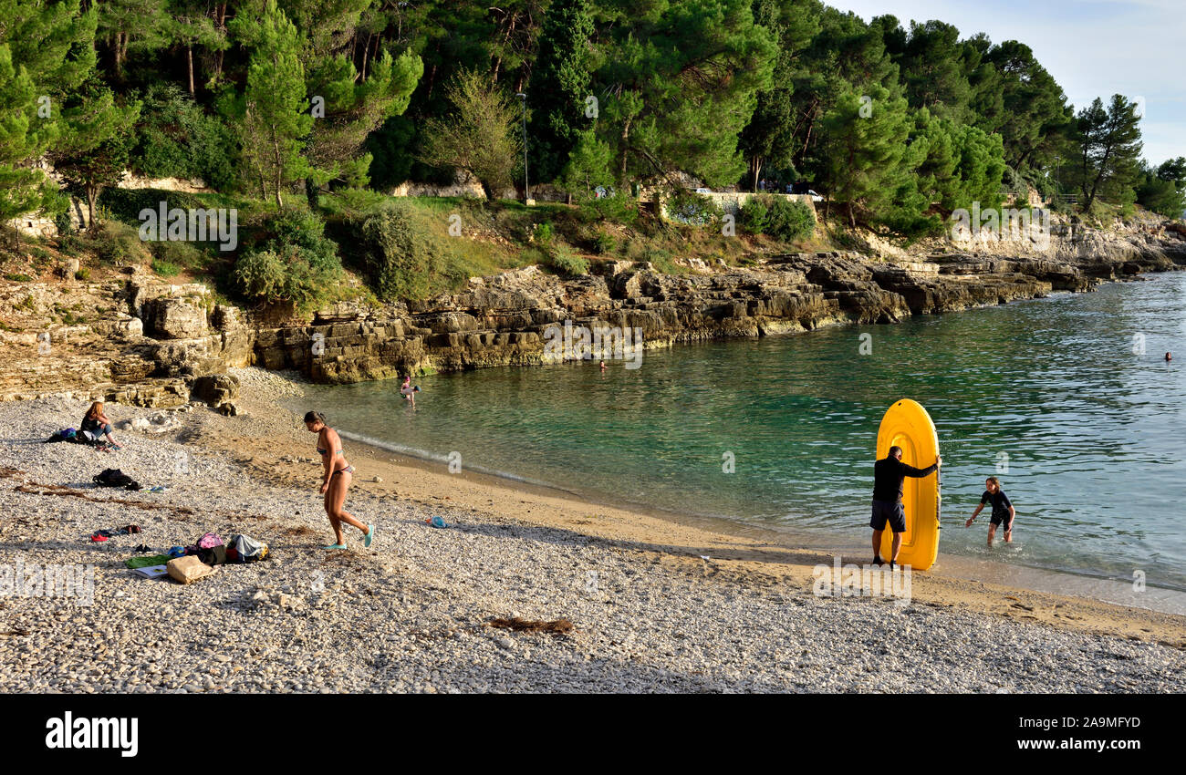 Strand und Küste mit Schwimmern im klaren Wasser der kleinen Bucht (Gortanova uvala) der Norden der Adria Kroatien Küste, in der Nähe von Pula Stockfoto