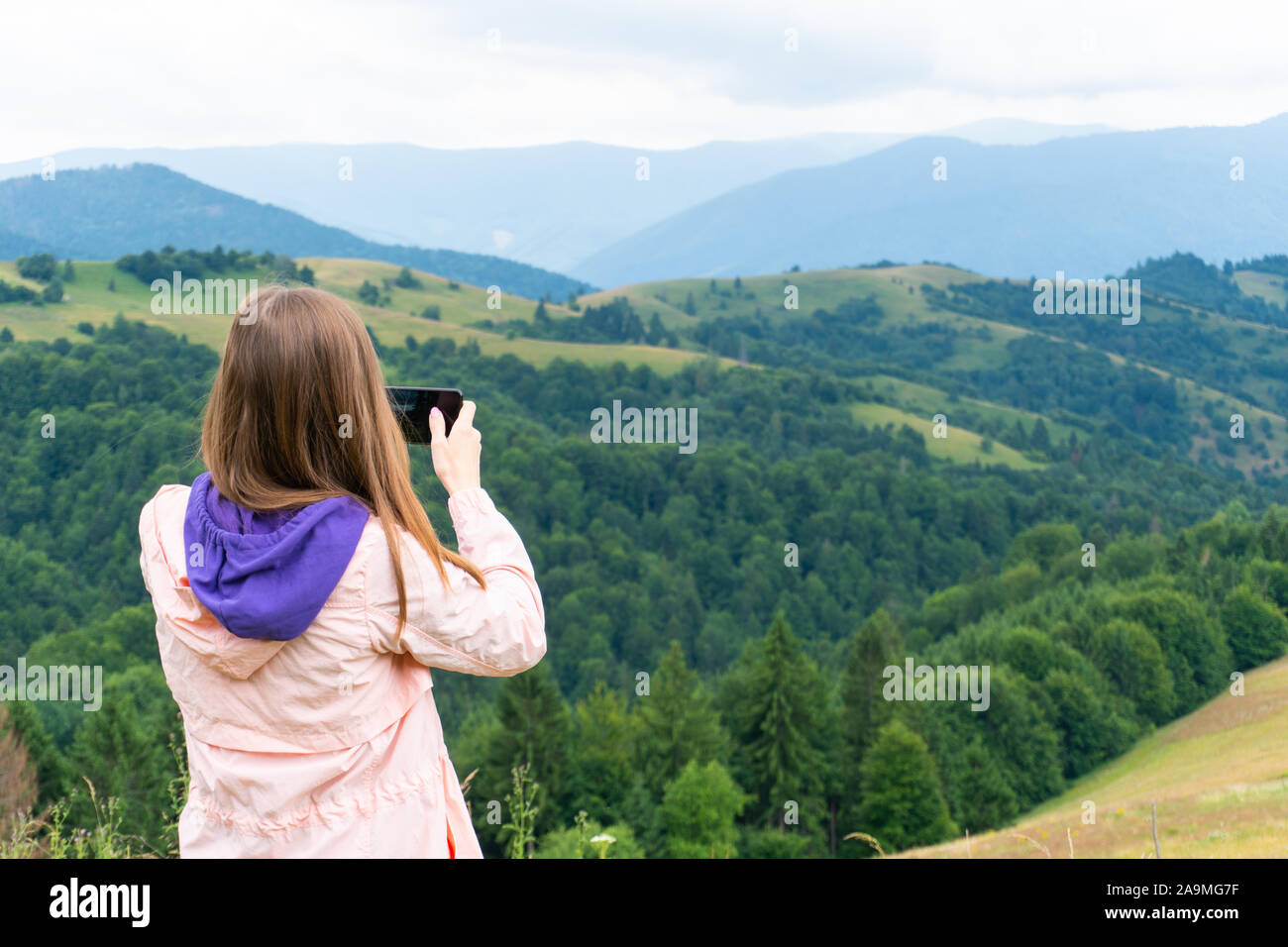 Frau, die Fotos von Bergen über Smartphone Stockfoto Frau, die Fotos von Bergen über Smartphone Stockfoto