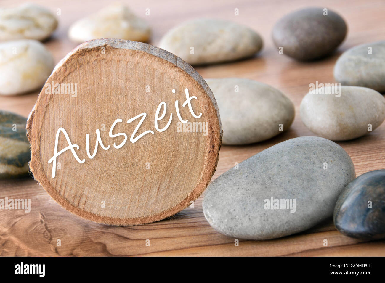 Deutsche Time-out Holzscheibe mit Steinen als Hintergrund Stockfoto