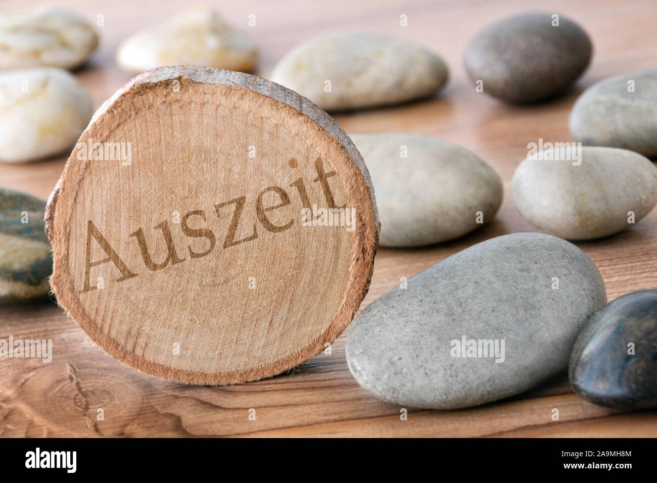 Deutsche Time-out Holzscheibe mit Steinen als Hintergrund Stockfoto