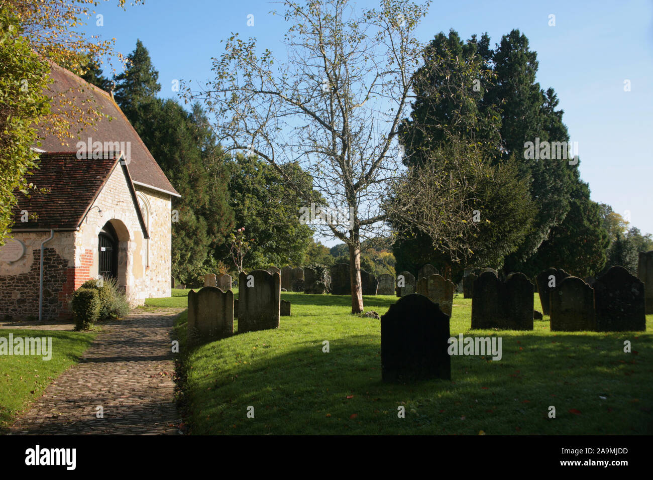 Weg zum Eingang Ost der St. Mary's Kirche, Selborne, Hampshire: Eine ruhige Szene auf dem Friedhof Stockfoto