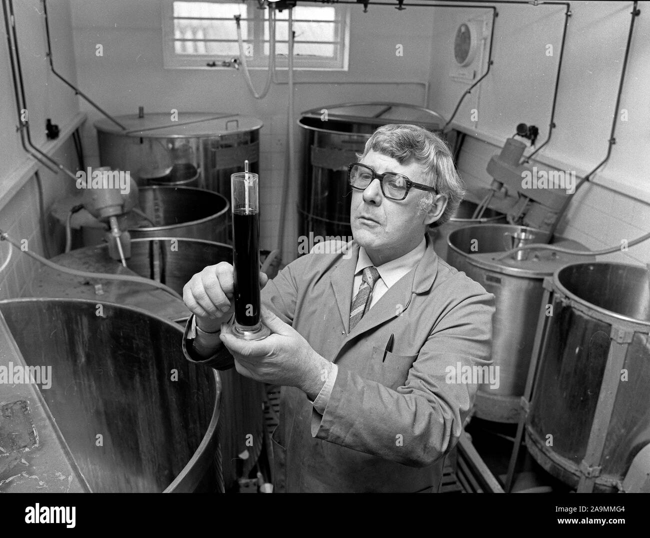 Brewer die Messung der Schwerkraft von Alkohol mit einem Dichtemesser, Großbritannien, Großbritannien 1985 Stockfoto