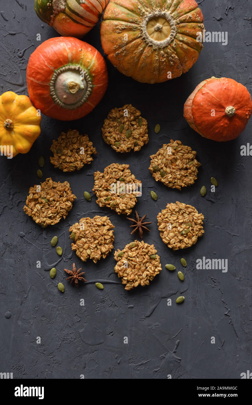 Vegan Glutenfrei Backen Konzept. Flatlay Frühstück hausgemachte oatmeal Cookies und winterkürbisse auf schwarzem Hintergrund Kopie Raum Stockfoto