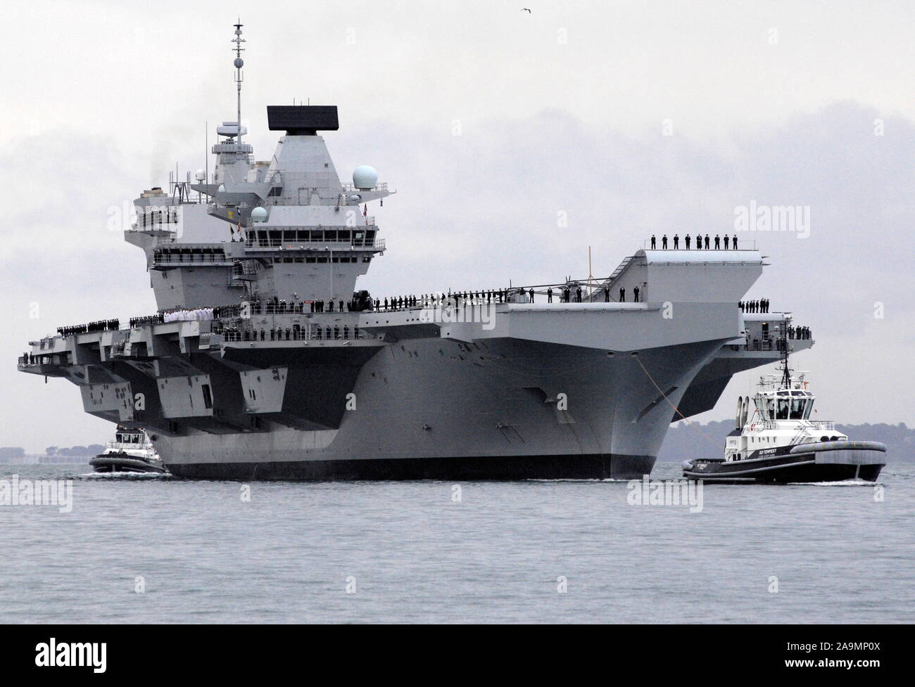 AJAXNETPHOTO. 16. AUGUST 2017. PORTSMOUTH, England. - Der größte Kriegsschiff der Royal Navy SEGEL IN HOME PORT-HMS KÖNIGIN ELIZABTH, DAS ERSTE VON ZWEI 65.000 Tonnen, 900 m lang, STATE-OF-THE-ART FLUGZEUGTRÄGER segelte in Portsmouth Naval Base in den frühen Stunden des Morgens sanft drückte und drängte durch sechs Schleppern in ihre neuen Liegeplatz auf der Princess Royal Jetty. Die £ 3 Mrd. FFR, das größte Kriegsschiff, das jemals gebaut wurde für die Royal Navy, KAM AN BEI IHR ZU HAUSE PORT ZWEI TAGE VOR IHREM URSPRÜNGLICHEN ZEITPLAN angekommen. Foto: Jonathan Eastland/AJAX REF: D 171608 6779 Stockfoto