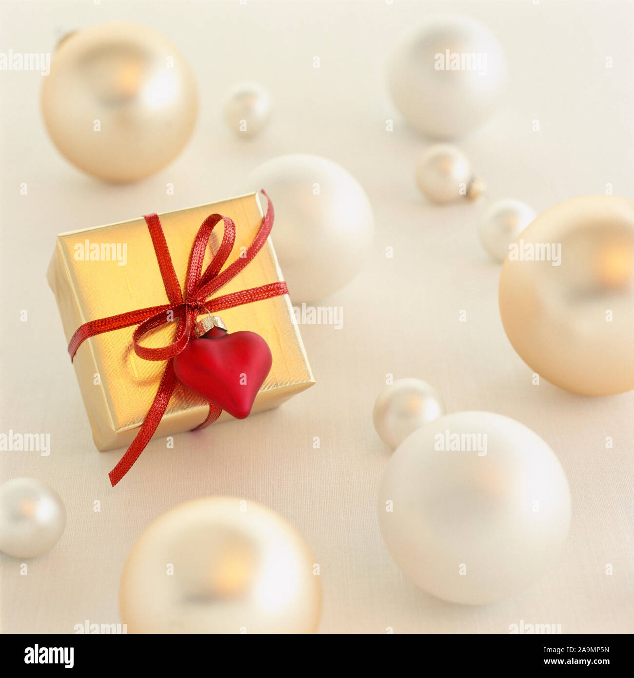 In der Nähe von romantischen Weihnachtsgeschenk präsentieren mit gold Geschenkpapier und rotes Herz Dekoration Weihnachten Ornamente auf weißem Hintergrund umgeben. S Stockfoto