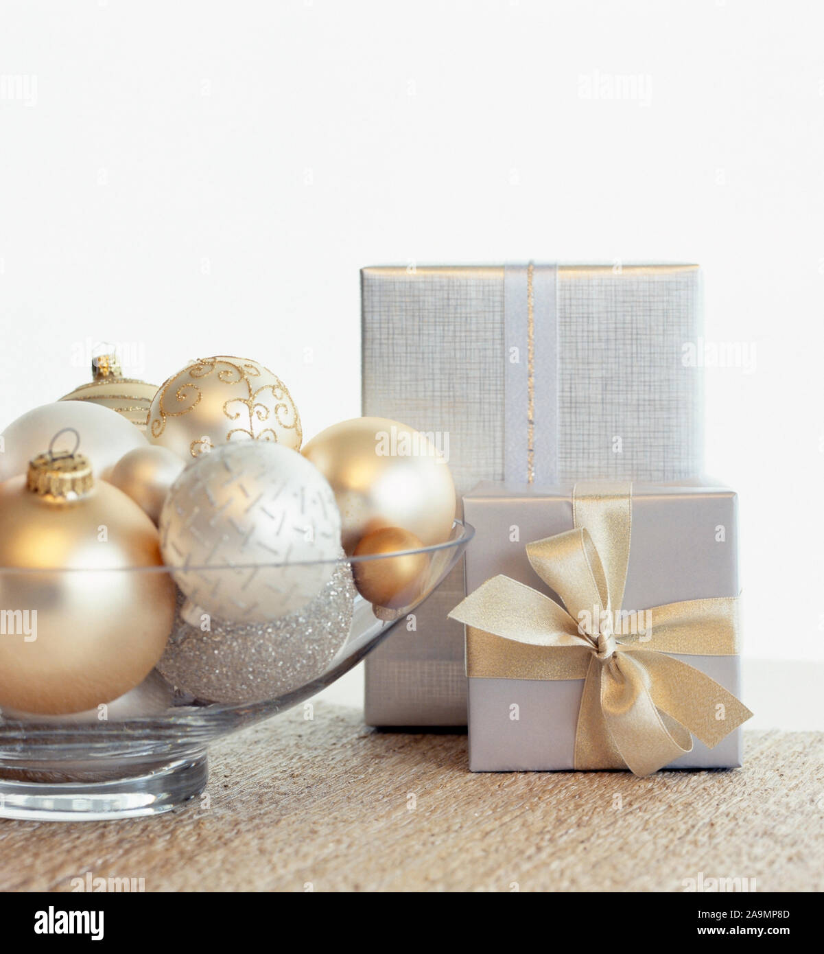 Schönes, elegantes Silber und Gold Weihnachten Geschenke und Glasgefäß Mittelstück mit Flitter Ornamente und weißen Hintergrund. Fancy, Ferienhaus Stockfoto