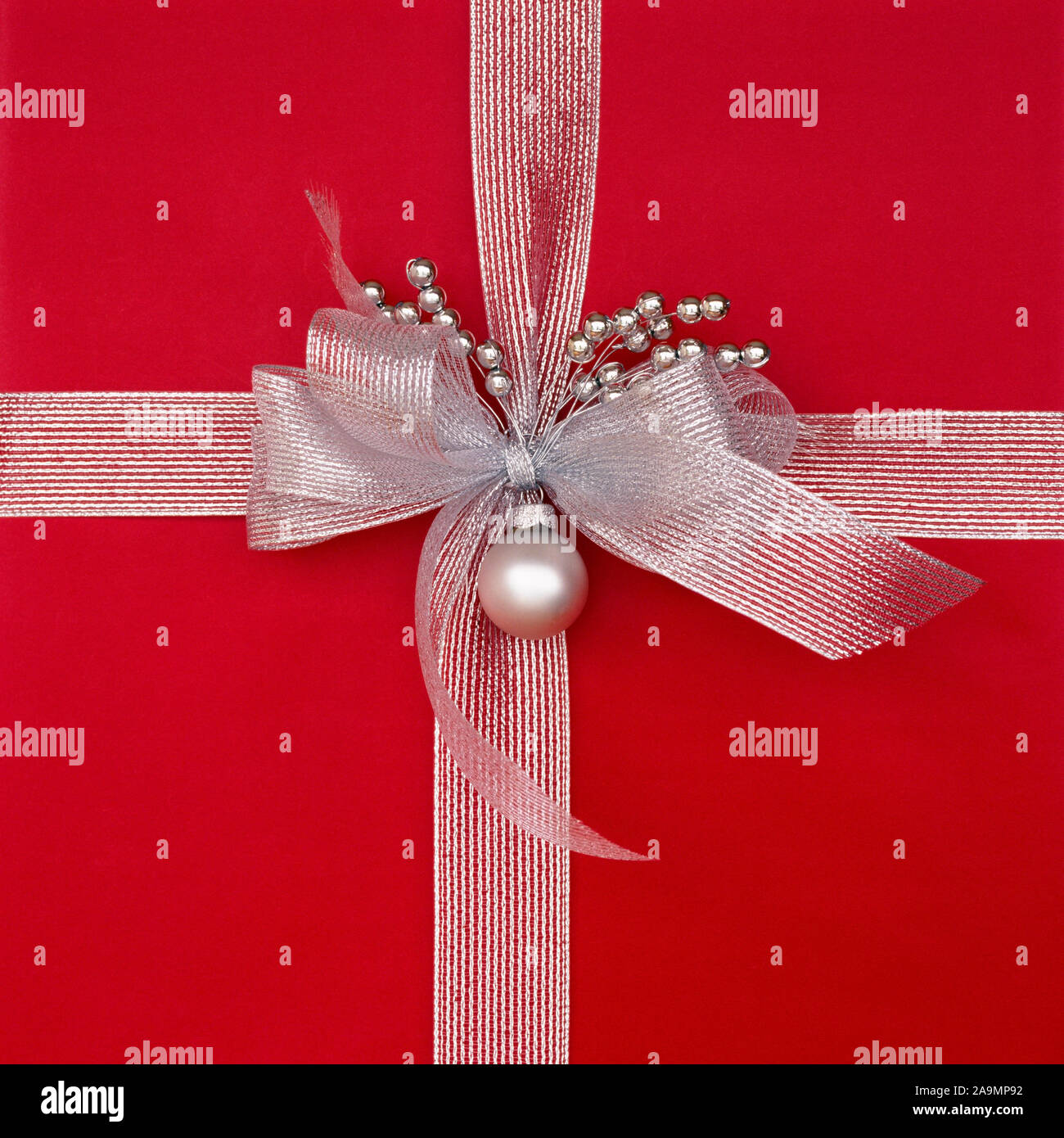 Nahaufnahme Nahaufnahme von roten Weihnachtsgeschenk präsentieren mit metallischem Silber Farbband, Bug und Dekorationen. Schönes, schickes, elegantes Weihnachtsgeschenke Hintergründe Stockfoto