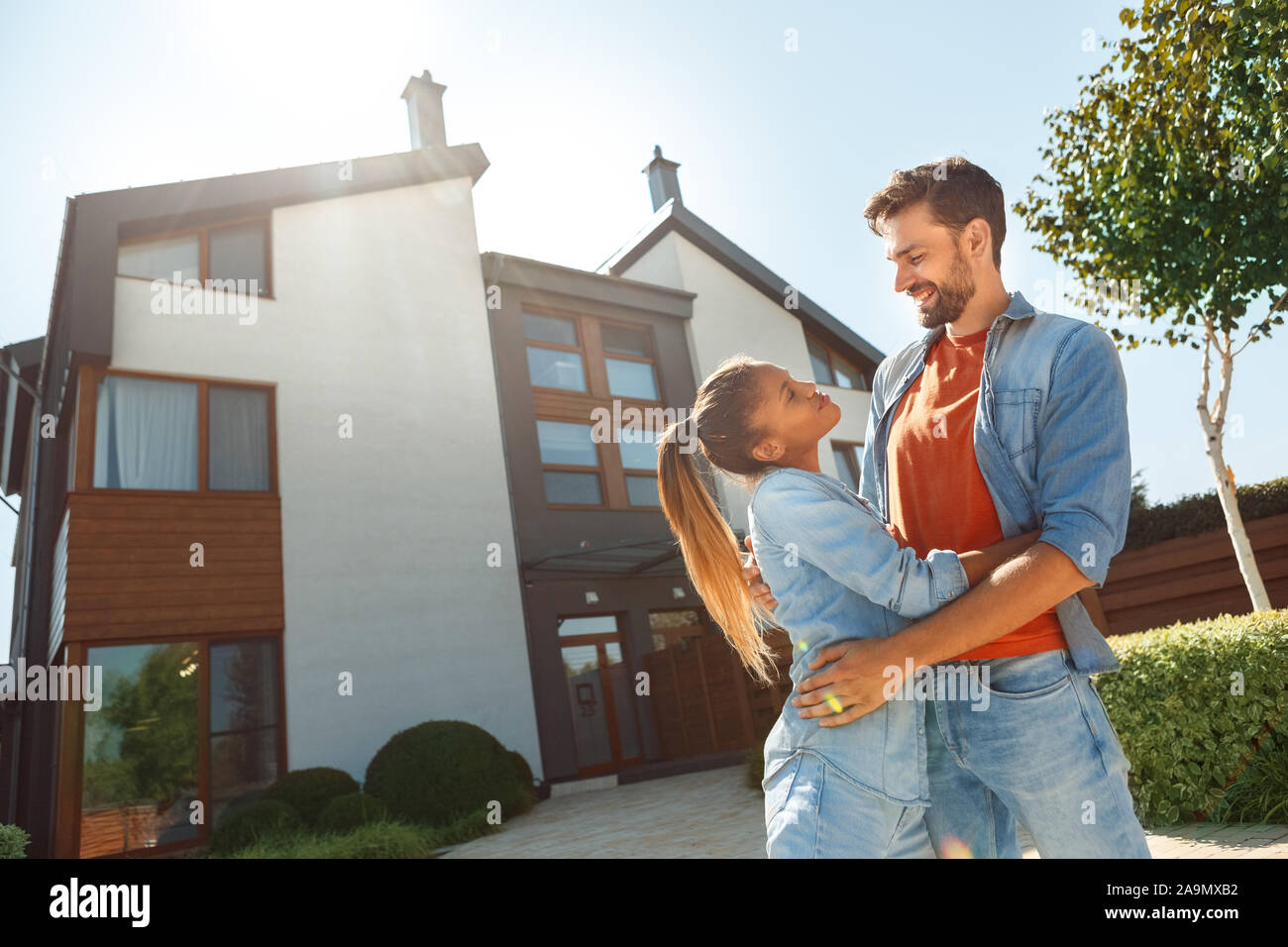 Junge erwachsene Frau und Mann gegen neue Haus zusammen Stockfoto