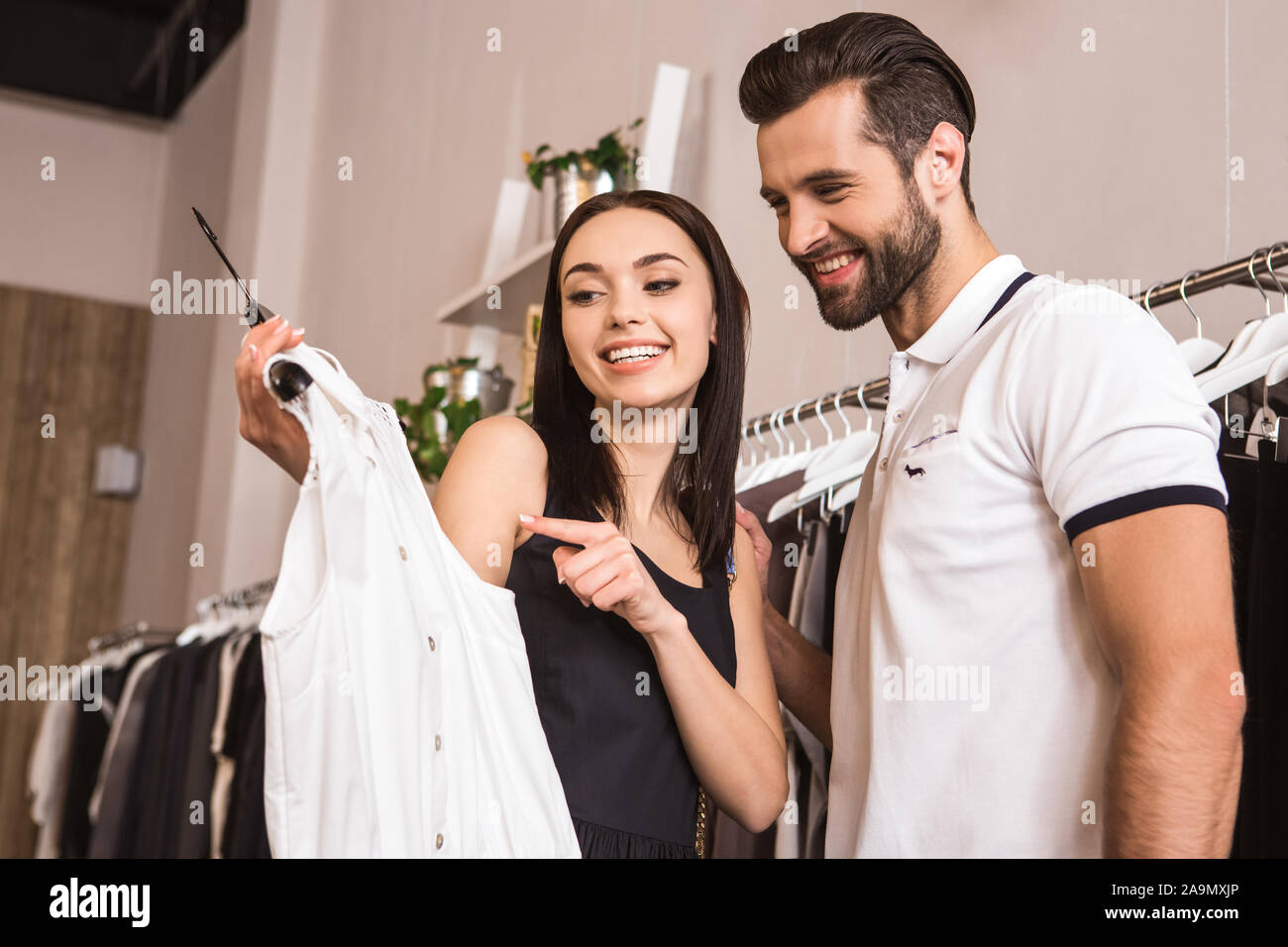 Junge Erwachsene Mann und Frau wählen neue Kleidung zusammen Stockfoto