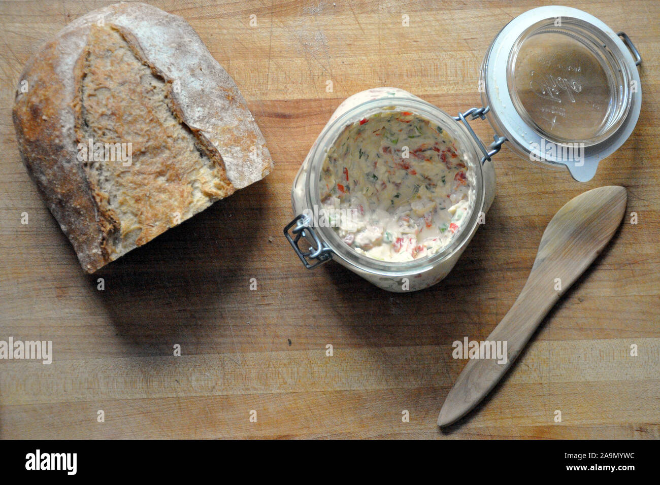 Pimento Käse in einem Glasbehälter mit Laib Brot Stockfoto